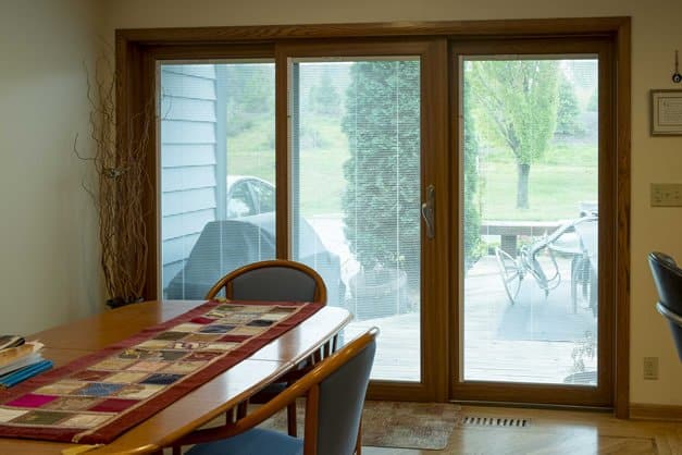 Image shows an interior dining area with a 3 pane patio door
