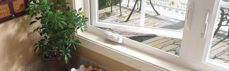 Image shows the interior of a casement window with a plant sitting next to it