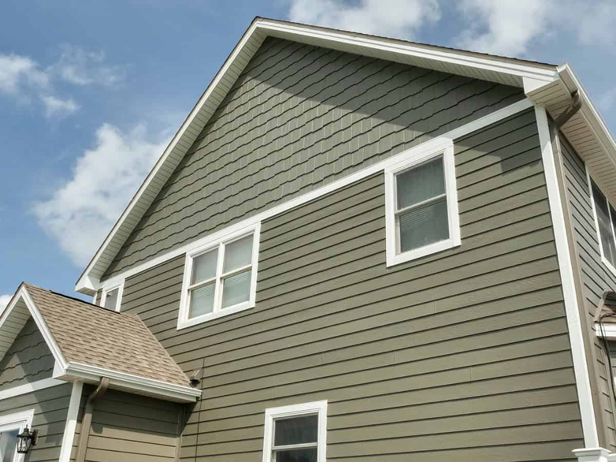 A two story house with dark, olive-brown colored siding.